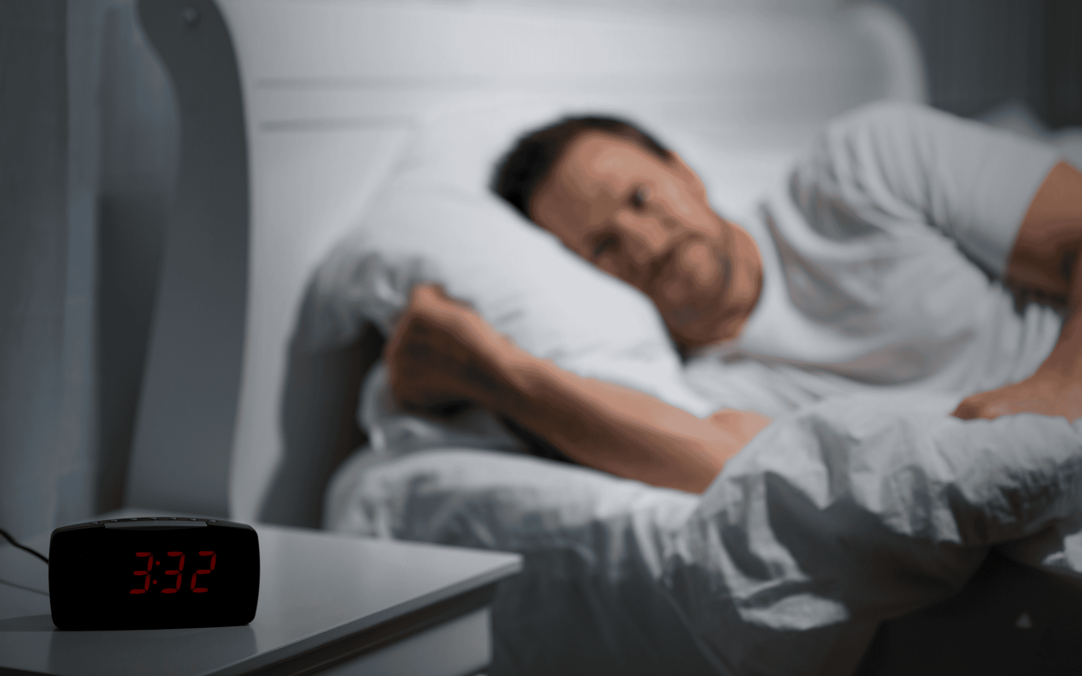 Man lying awake in bed in the middle of the night, struggling with insomnia and sleep disruption, capturing the elusive and essential nature of rest during grief.