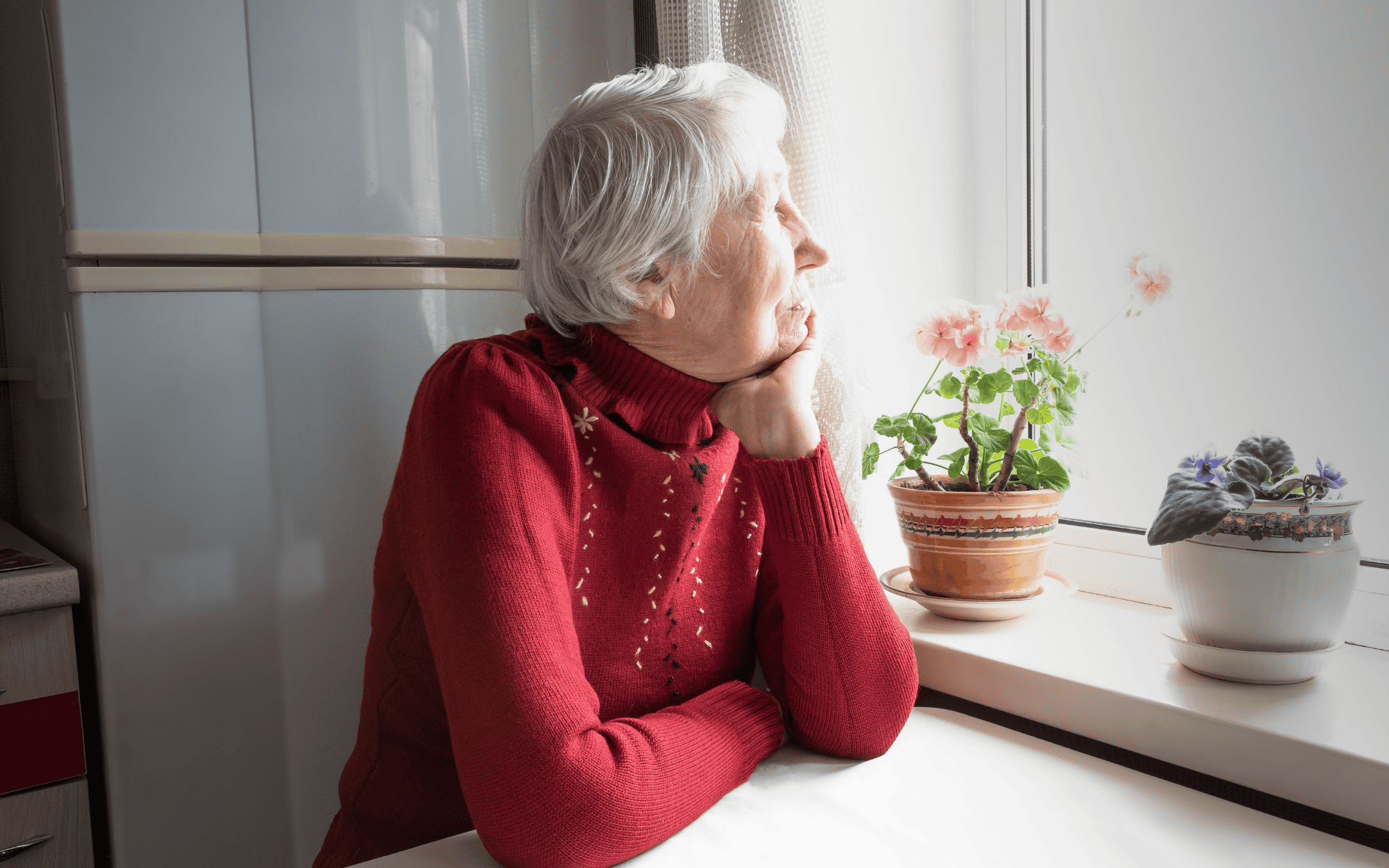 Elderly woman patiently looking out a bright window, head resting on her arm, symbolizing the need for patience and time in healing from stress and grief.